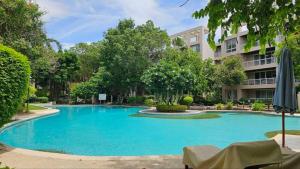 a large blue swimming pool in front of a building at Baan Sansaran Excellent apartment on the beach with a large territory and swimming pools. in Hua Hin