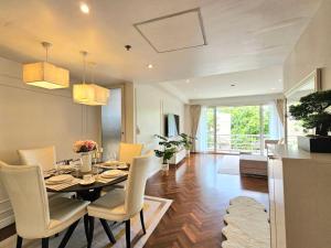 a dining room and living room with a table and chairs at Baan Sansaran Excellent apartment on the beach with a large territory and swimming pools. in Hua Hin