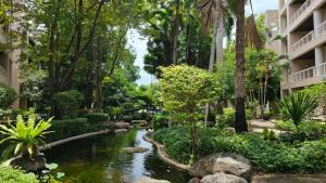 a garden with a pond in a resort at Baan Sansaran Excellent apartment on the beach with a large territory and swimming pools. in Hua Hin