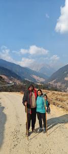 duas pessoas de pé ao lado de uma estrada de terra batida em Dhauladhar Woodhouse em Malotha