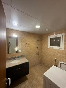 uma casa de banho com um lavatório e um espelho em بيت السلطانة للأجنحة الفندقية em Salalah