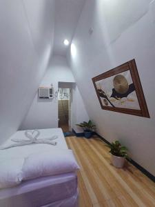 ein Schlafzimmer mit einem Bett und einem Wandgemälde in der Unterkunft King Odin's A-House in Catarman