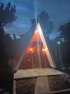 ein kleines rotweißes Haus mit Licht drauf in der Unterkunft King Odin's A-House in Catarman