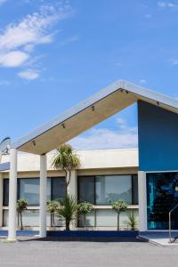 a building with palm trees in front of it at Robetown Motor Inn & Apartments in Robe