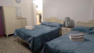 a bedroom with two beds and a dresser and a mirror at Strenua - Las Quintanas in Trujillo