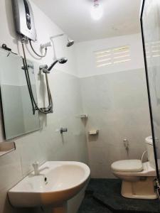 W łazience znajduje się prysznic, umywalka i toaleta. w obiekcie Lotus cool hotel and restaurant w mieście Ibbagomuwa