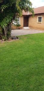 a yard with green grass and a house at Molata Rabs in Polokwane
