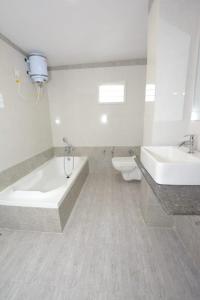 a bathroom with two sinks and a tub and a toilet at HOTEL GREEEN LEAF in Anand