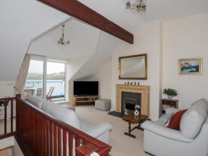a living room with white furniture and a fireplace at Dornberg in Y Felinheli