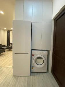 a white refrigerator and a washing machine in a room at Apartment in Yerevan in Yerevan