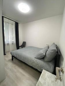 a bedroom with a bed and a chair and a window at Apartment in Yerevan in Yerevan