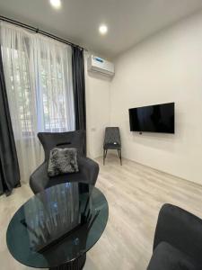 a living room with a couch and a table and a tv at Apartment in Yerevan in Yerevan