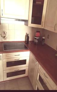 uma cozinha com armários brancos e uma bancada em Slunný byt v 7 patře em Praga