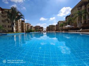 a large swimming pool in a resort with buildings at In the heart of Cairo in Cairo