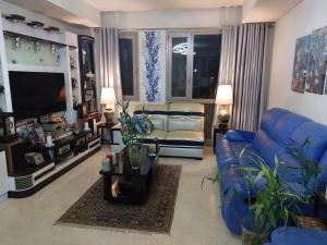 ein Wohnzimmer mit blauen Sofas und einem TV in der Unterkunft In the heart of Cairo in Kairo