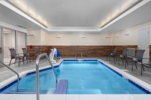 a pool in a hotel room with chairs around it at Fairfield Inn & Suites by Marriott Kenosha Pleasant Prairie in Pleasant Prairie