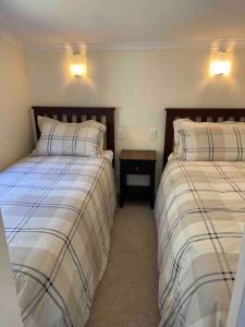 a bedroom with two beds and a nightstand between them at The Lake House at Waikaremoana in Tuai