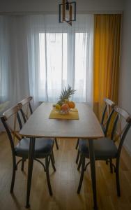 - une table en bois avec des chaises et une assiette de fruits dans l'établissement Tera apartment Zemun, à Belgrade