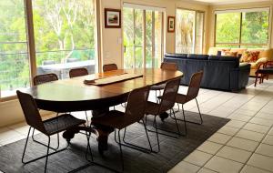 a dining room table and chairs in a living room at Nambucca Beach House in Nambucca Heads