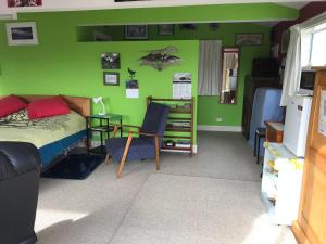 een slaapkamer met een bed en een groene muur bij Piringa in Dunedin