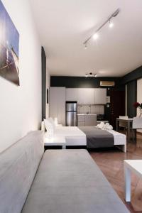 Una sala de estar con dos camas y una cocina. en OUR Luxury Studio, en Kavala