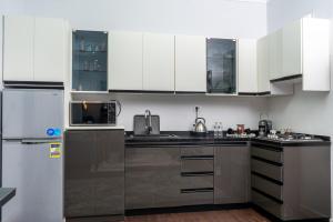 a kitchen with white cabinets and stainless steel appliances at Premium apartment in new cairo in Cairo