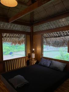 Làng Cac的住宿－Tớ Dày Du Già Village，卧室配有床,位于带2个窗户的房间