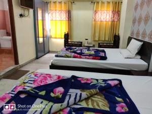 two beds in a room with colorful blankets at Hotel Gokul Palace in Udaipur