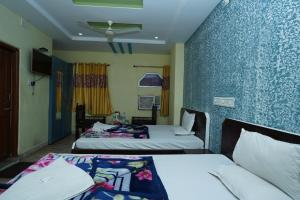 a hotel room with two beds and a ceiling at Hotel Gokul Palace in Udaipur