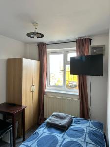 a bedroom with a bed and a television and a window at North London Property in London