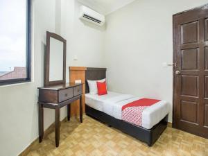 a bedroom with a bed and a dresser and a mirror at Grand Inn Hotel Semporna in Semporna