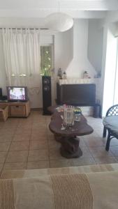 a living room with a table and a tv at House on the beach in Niforeika