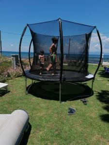 two children are playing on a trampoline at House on the beach in Niforeika