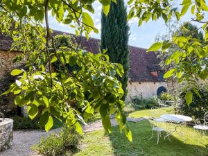 un jardin avec une table, des chaises et un arbre dans l'établissement Domaine de pragelier, à Tourtoirac 5 autres photos