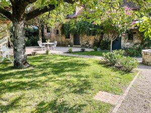un jardin avec une table, des chaises et un arbre dans l'établissement Domaine de pragelier, à Tourtoirac