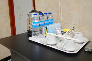 a tray with cups and bottles of water on a counter at Dya Hotel Boyolali in Boyolali