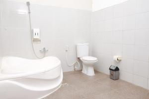 een witte badkamer met een wastafel en een toilet bij Dya Hotel Boyolali in Boyolali