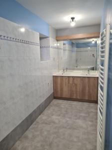 a bathroom with a tub and a sink and a mirror at Aux P'tits Cabris in Lahayville +29 photos