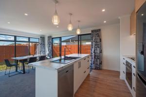 a kitchen with white cabinets and a dining room with a table at The Shepherds Retreat in Richmond