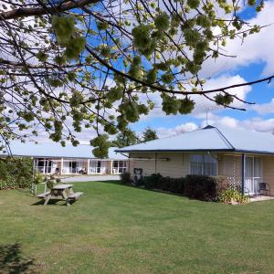 a building with a picnic table in the yard at Lake Dunstan Motel in Cromwell