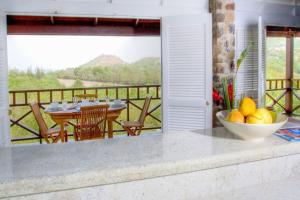 una cocina con mesa y un bol de fruta en una barra en Bright & Beautiful 2 Bedroom Villa en Cap Estate