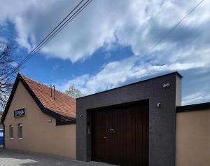 a building with a garage with a brown garage door at Duga Apartmani 3 in Subotica