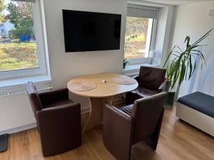 a living room with a table and chairs and a tv at Modernes Apartment, ruhige Lage, stadtnah in Kelkheim +7 photos