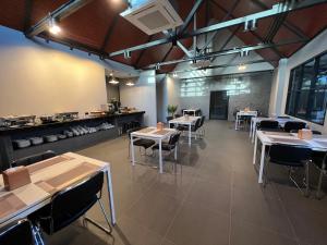 un ristorante con tavoli e sedie in una stanza di THE HUB SURATTHANl a Suratthani