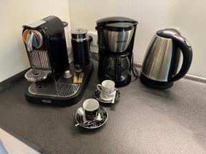 a coffee maker and coffee cups on a counter at Modernes Apartment, ruhige Lage, stadtnah in Kelkheim