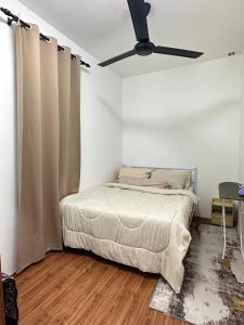 sypialnia z łóżkiem i wentylatorem sufitowym w obiekcie Amir Homestay w mieście Yong Peng