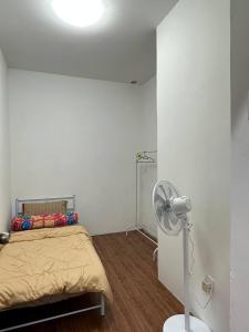 a white room with a bed and a fan at Amir Homestay in Yong Peng +3 photos