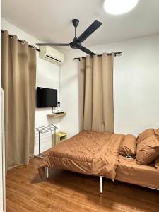 - une chambre avec un lit et un ventilateur de plafond dans l'établissement Amir Homestay, à Yong Peng
