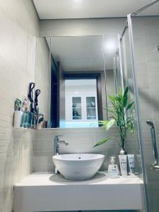 bagno con lavandino bianco e specchio di Studio cao cấp Vinhomes Greenbay Mễ trì giá rẻ nhất Hà Nội a Hanoi