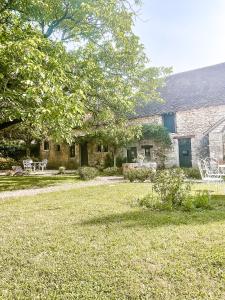 una casa in pietra con un cortile con sedie e un albero di Domaine de pragelier a Tourtoirac